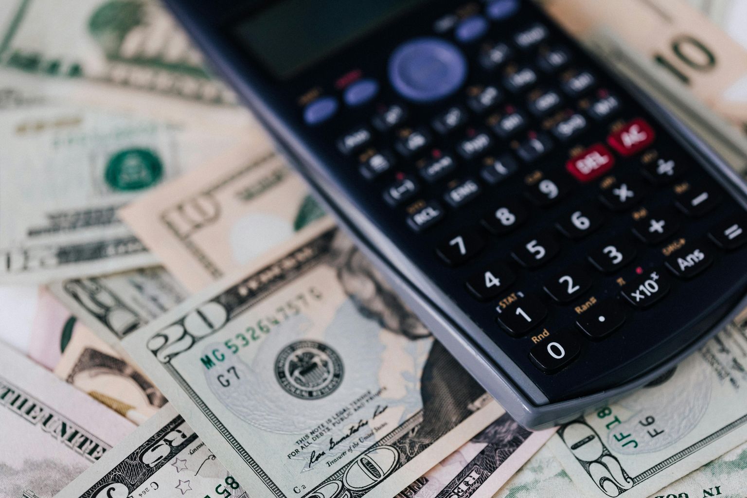 Calculator Placed over Stack of USA dollars