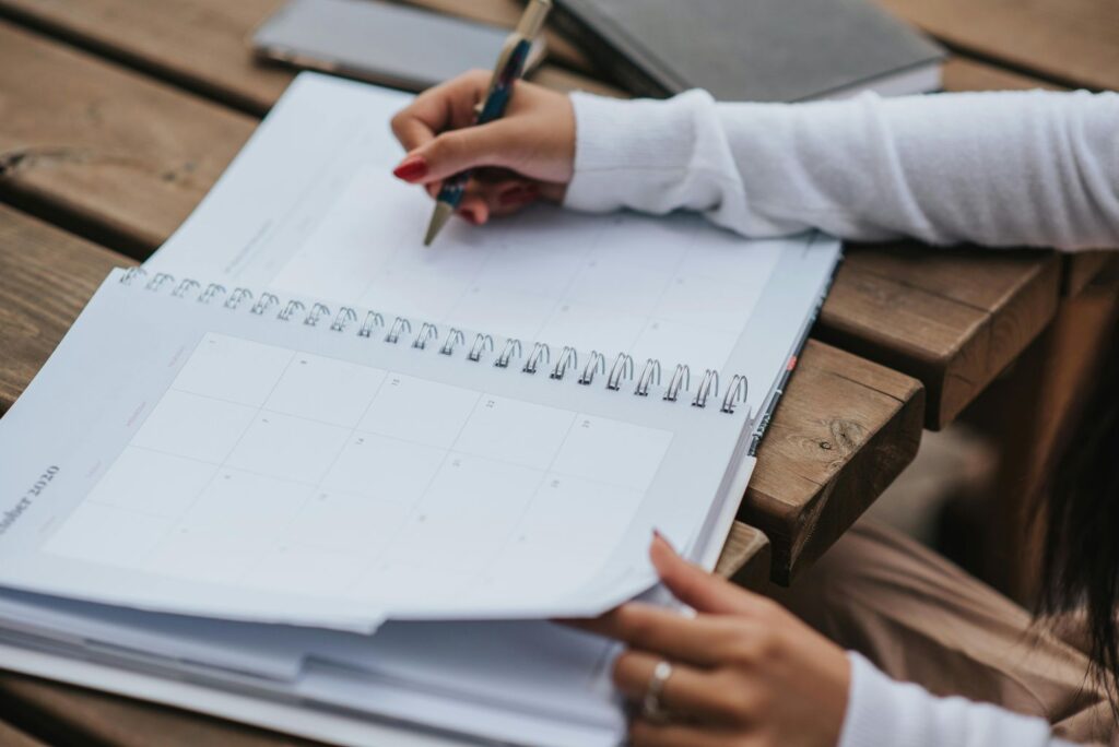 Crop woman making schedule in planner