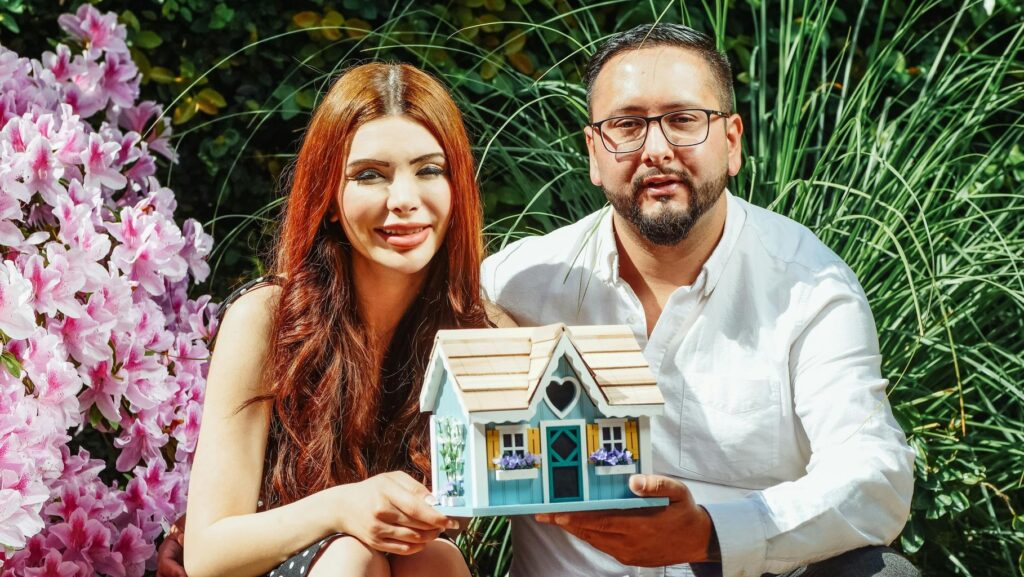 Couple Holding Miniature House