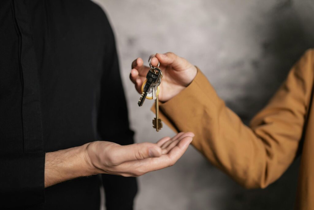 A Person Giving a Bundle of Keys to another Person