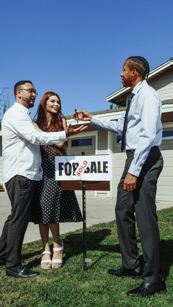 Man in Dress Shirt Handing House Key to a Couple