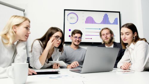 Man and Woman Sitting at Table With Macbook