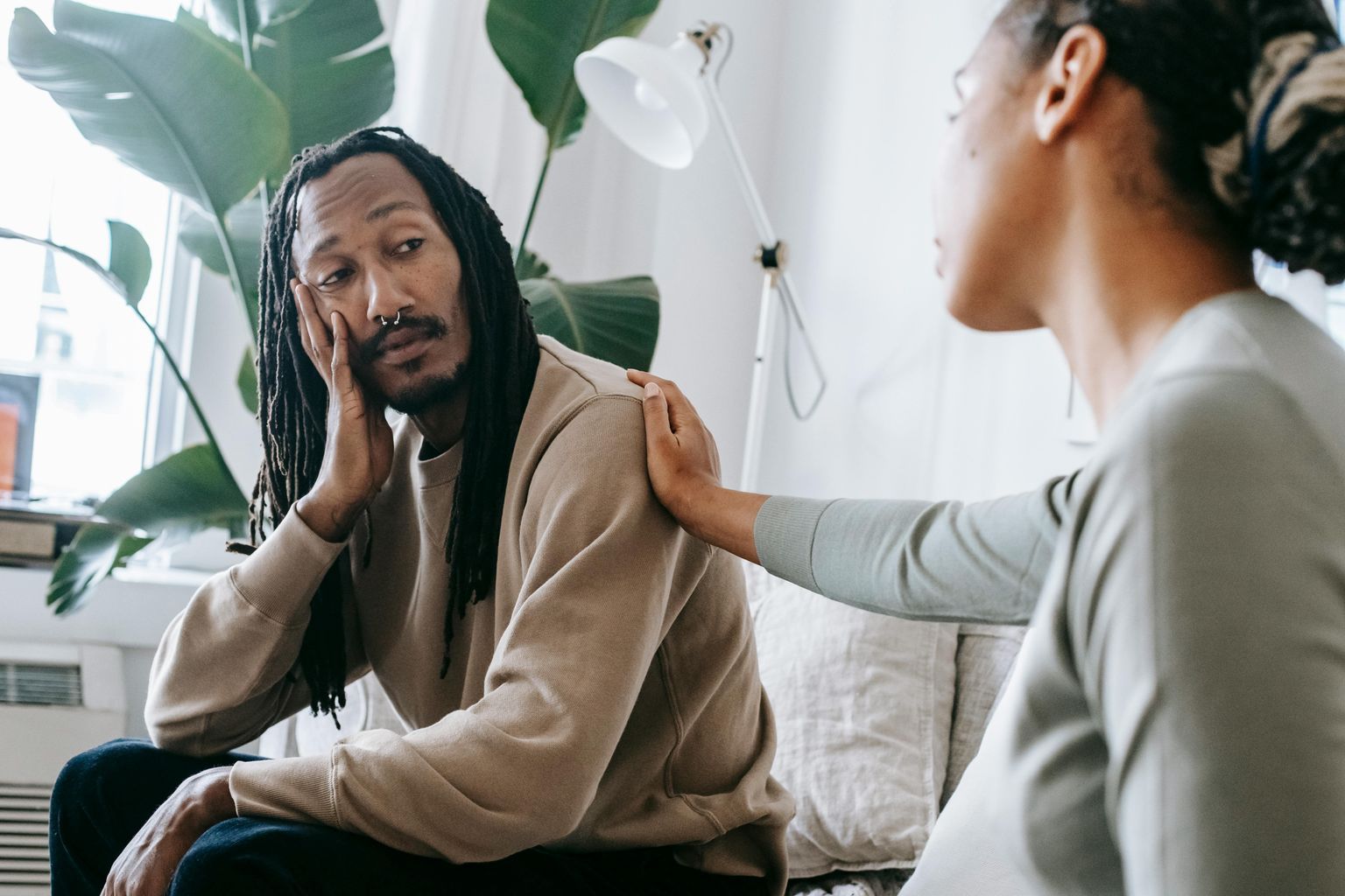 Ethnic psychologist touching black depressed clients shoulder