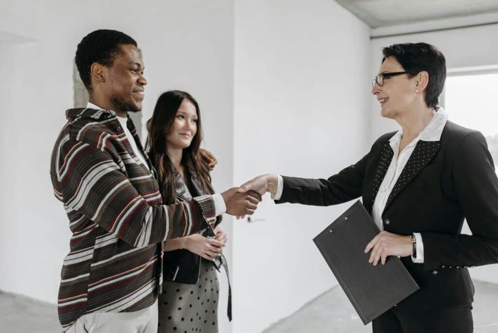 A Female Realtor Shaking Hands with Her Client